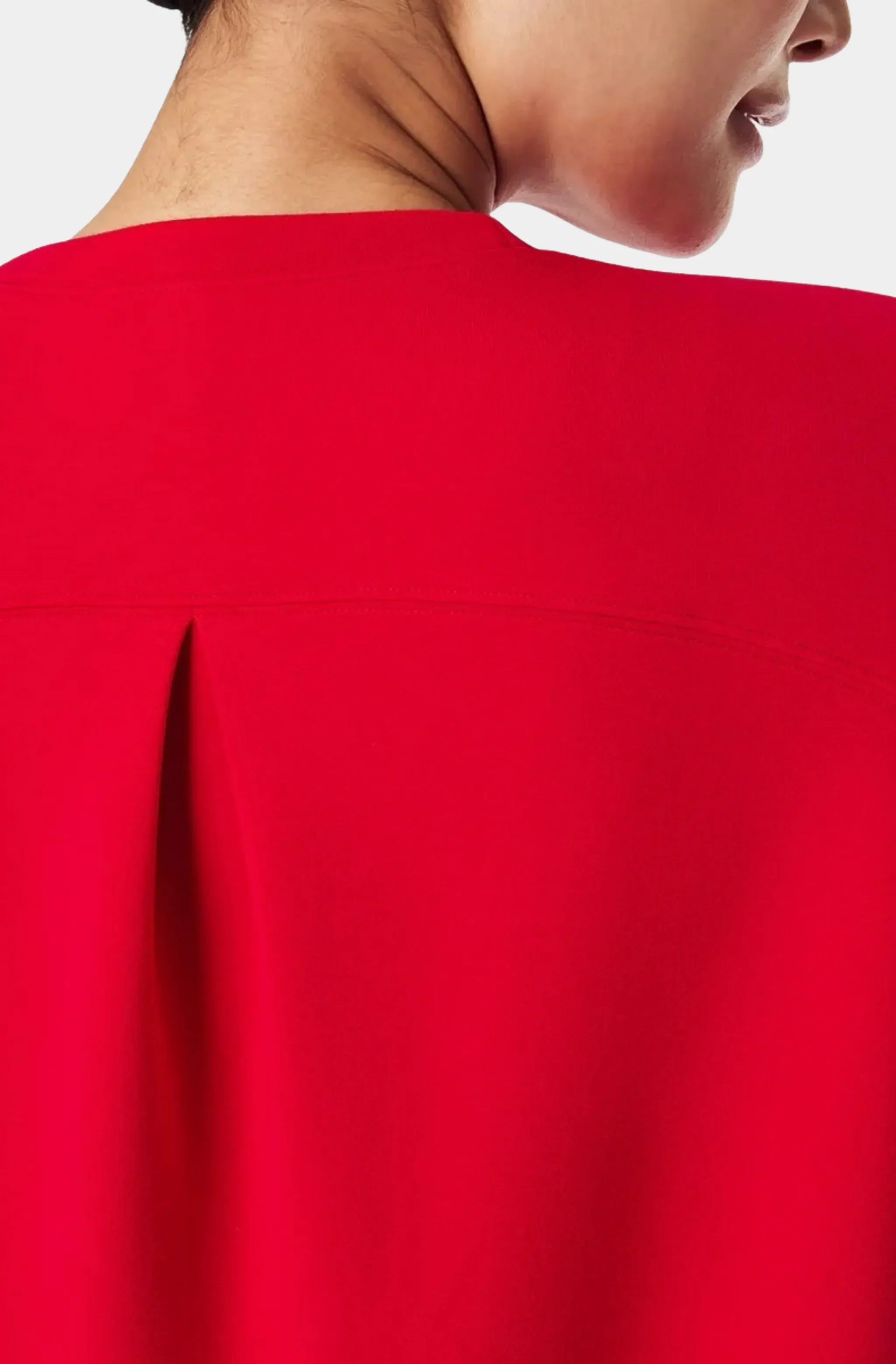 Close-up of red dress back pleat detail