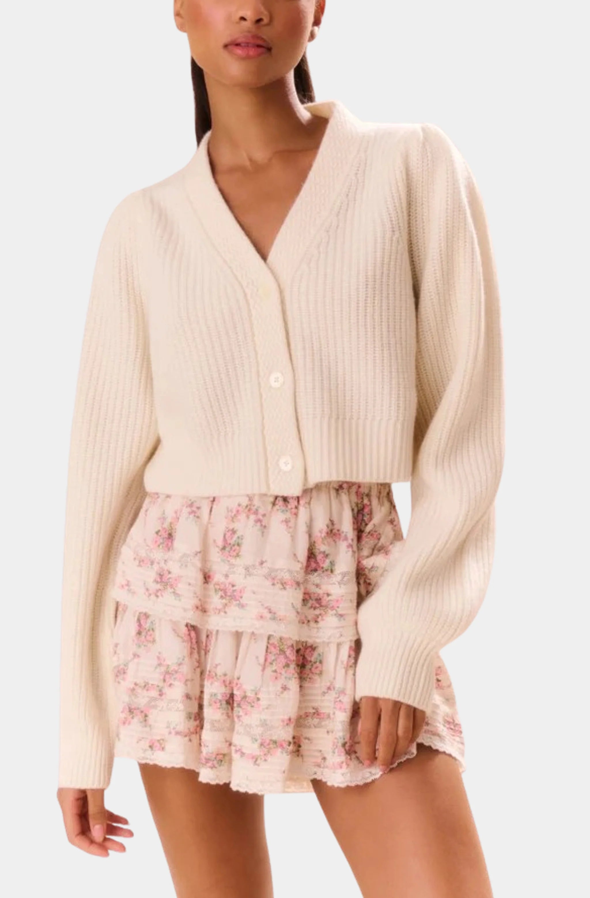 Front view of floral ruffle mini skirt and cream sweater ensemble.